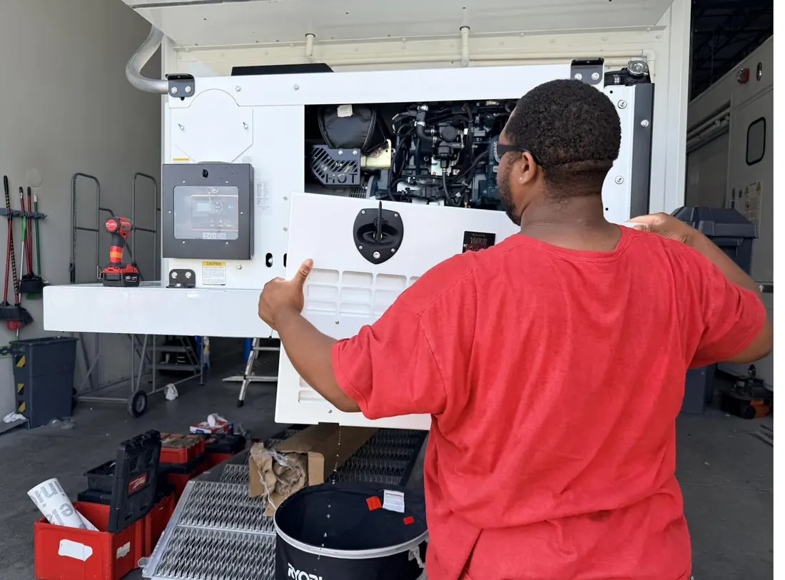 TreVince inspecting the diesel generator compartment of a mobile medical trailer